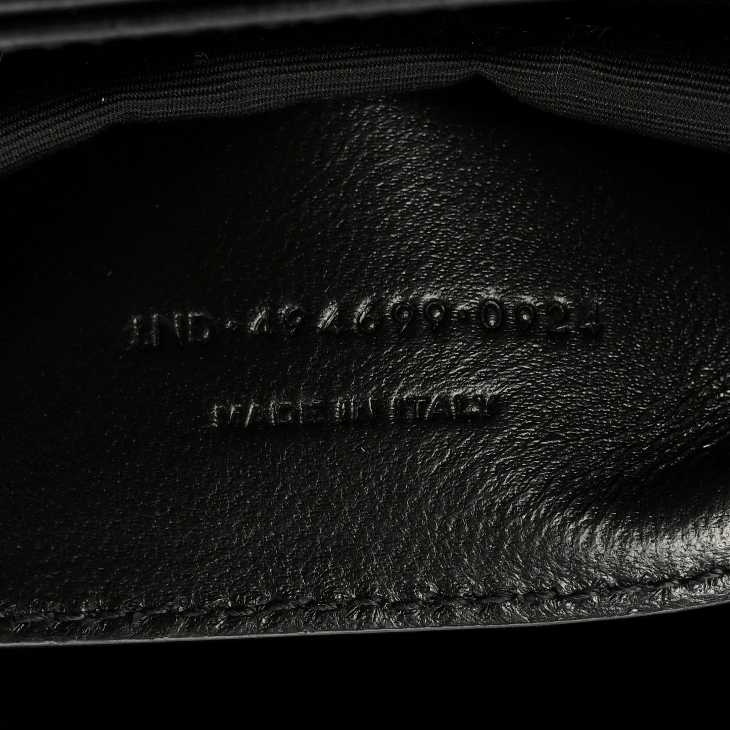 Black leather interior lining with embossed markings and curved seam detail.