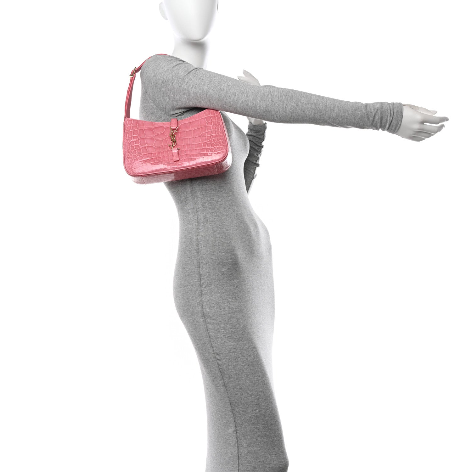 Pink alligator-textured hobo bag held in hand, showing top handle and front logo charm
