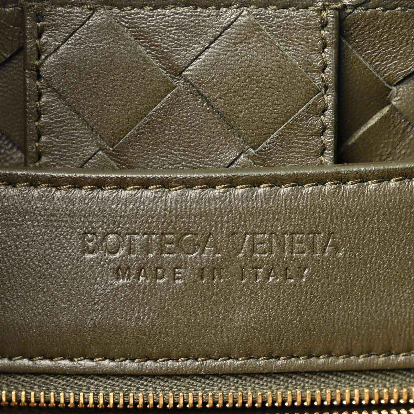 Bottega Veneta leather bag front panel with woven texture and embossed brand mark