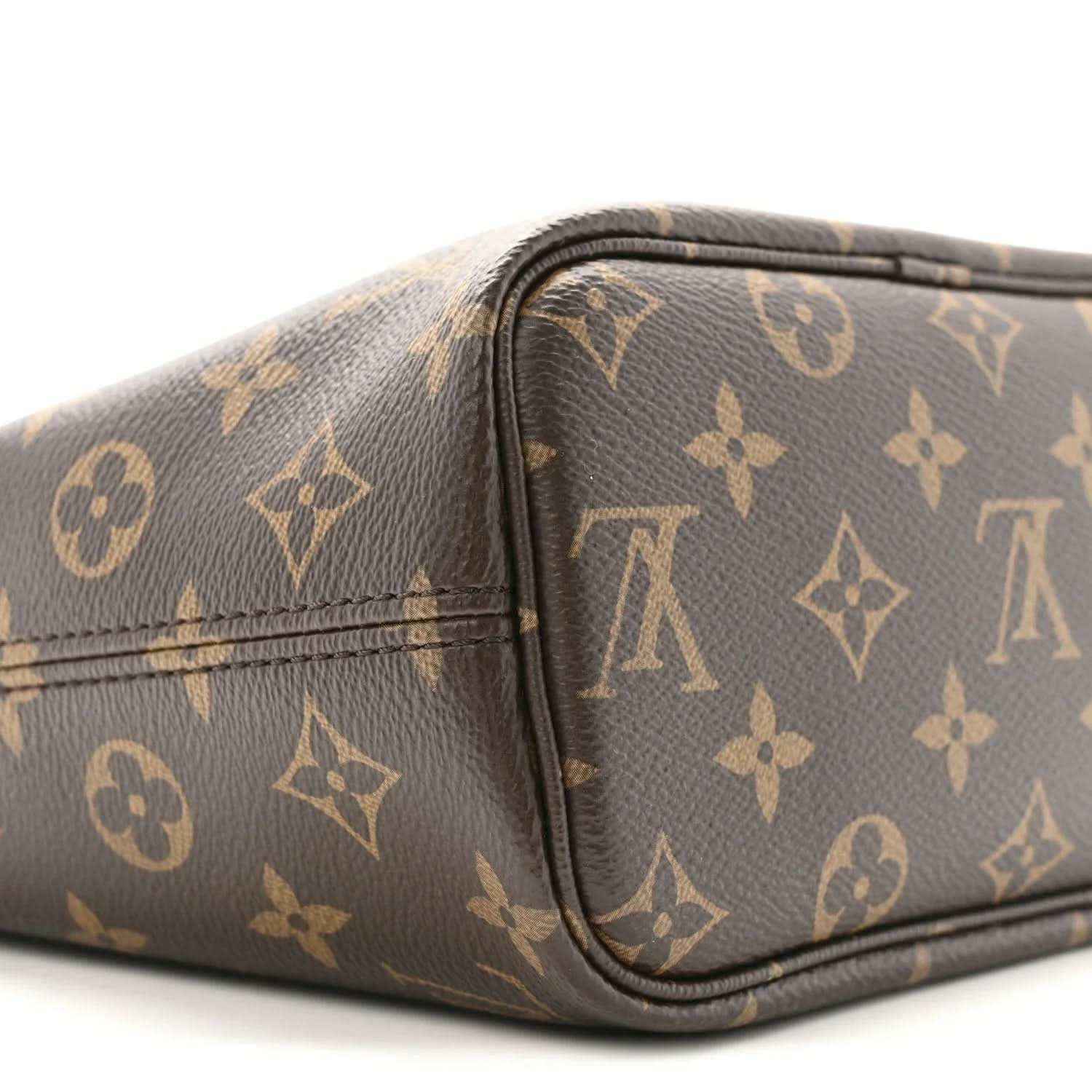Monogram side view of mini pouch with rounded corners, black zipper trim, and brown pattern