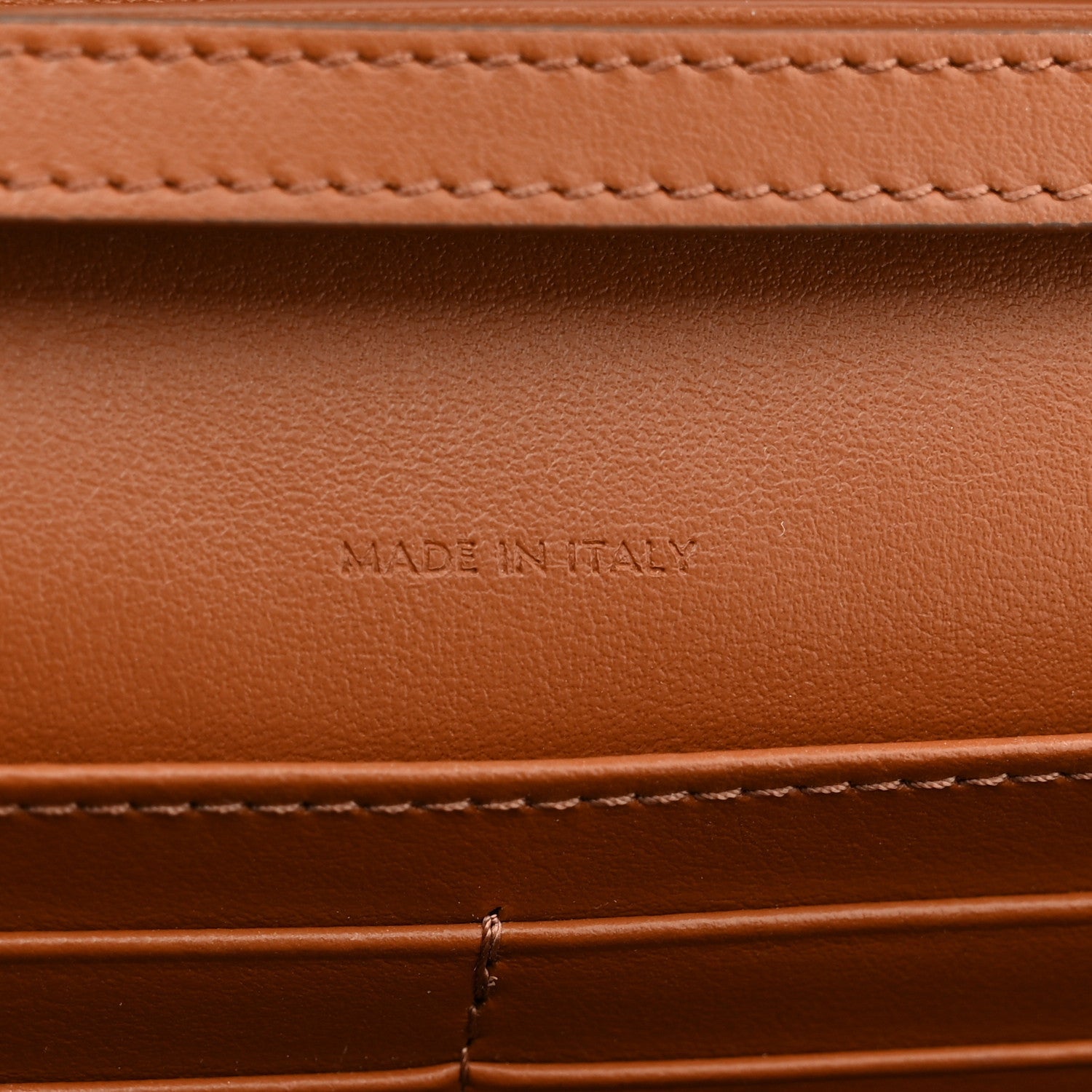 Tan leather interior with "MADE IN ITALY" embossed text and stitching