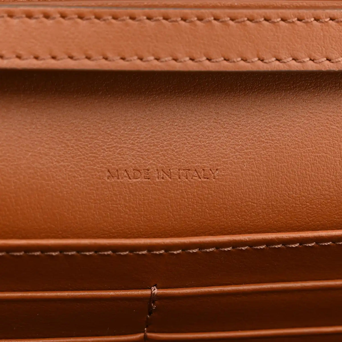 Tan leather interior with "MADE IN ITALY" embossed text and stitching