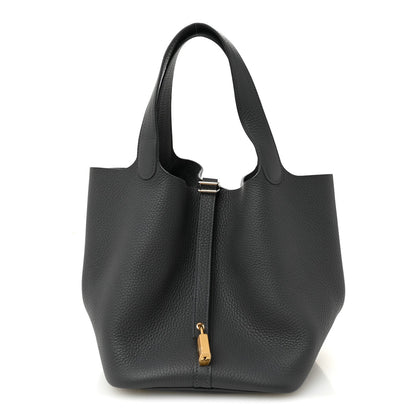 Small leather tote bag in dark gray with top handles and front vertical zip detail