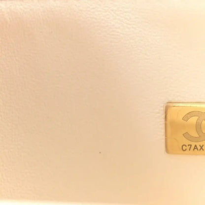 White quilted leather bag corner with gold-tone hardware plaque