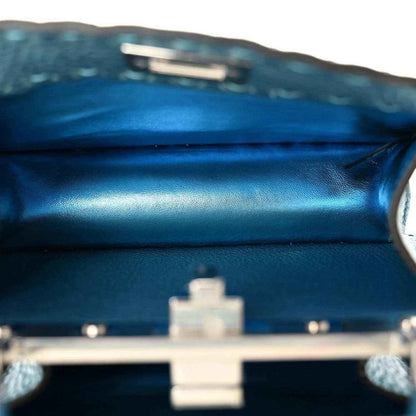Blue leather satchel with centered metal turn-lock clasp on the front.
