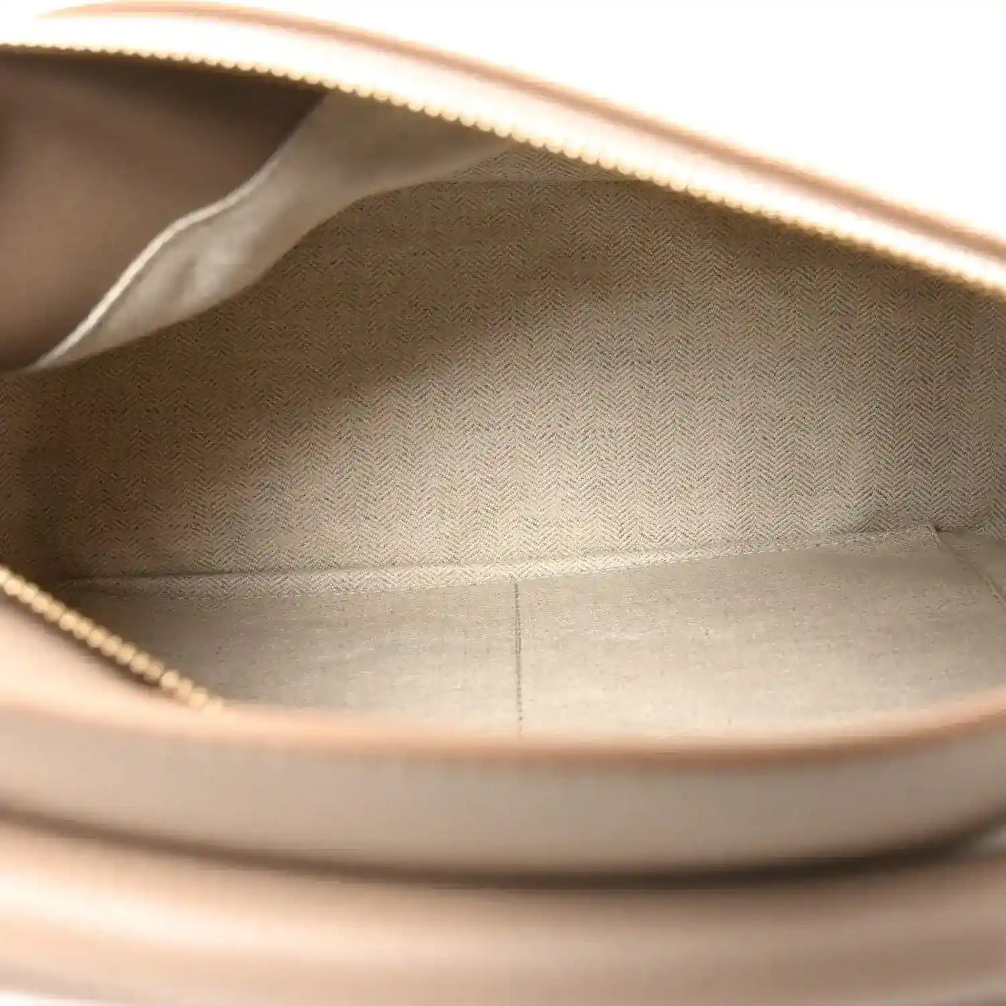 Sand leather bag interior opening with stitched lining and visible top edge.