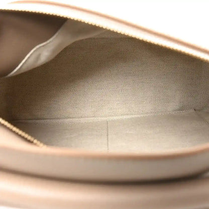 Sand leather bag interior opening with stitched lining and visible top edge.