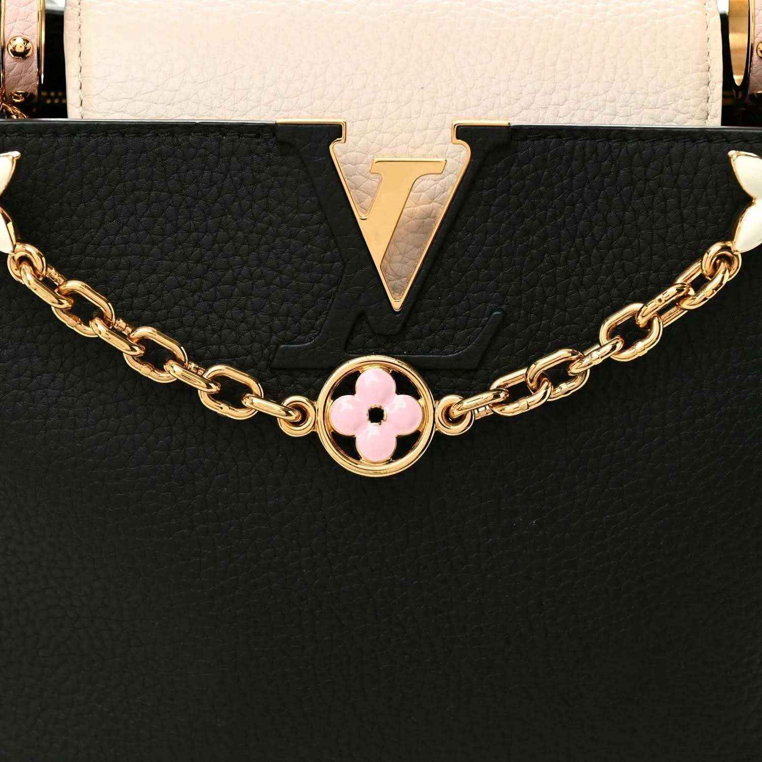 Black and cream leather handbag with gold chain and pink flower logo charm