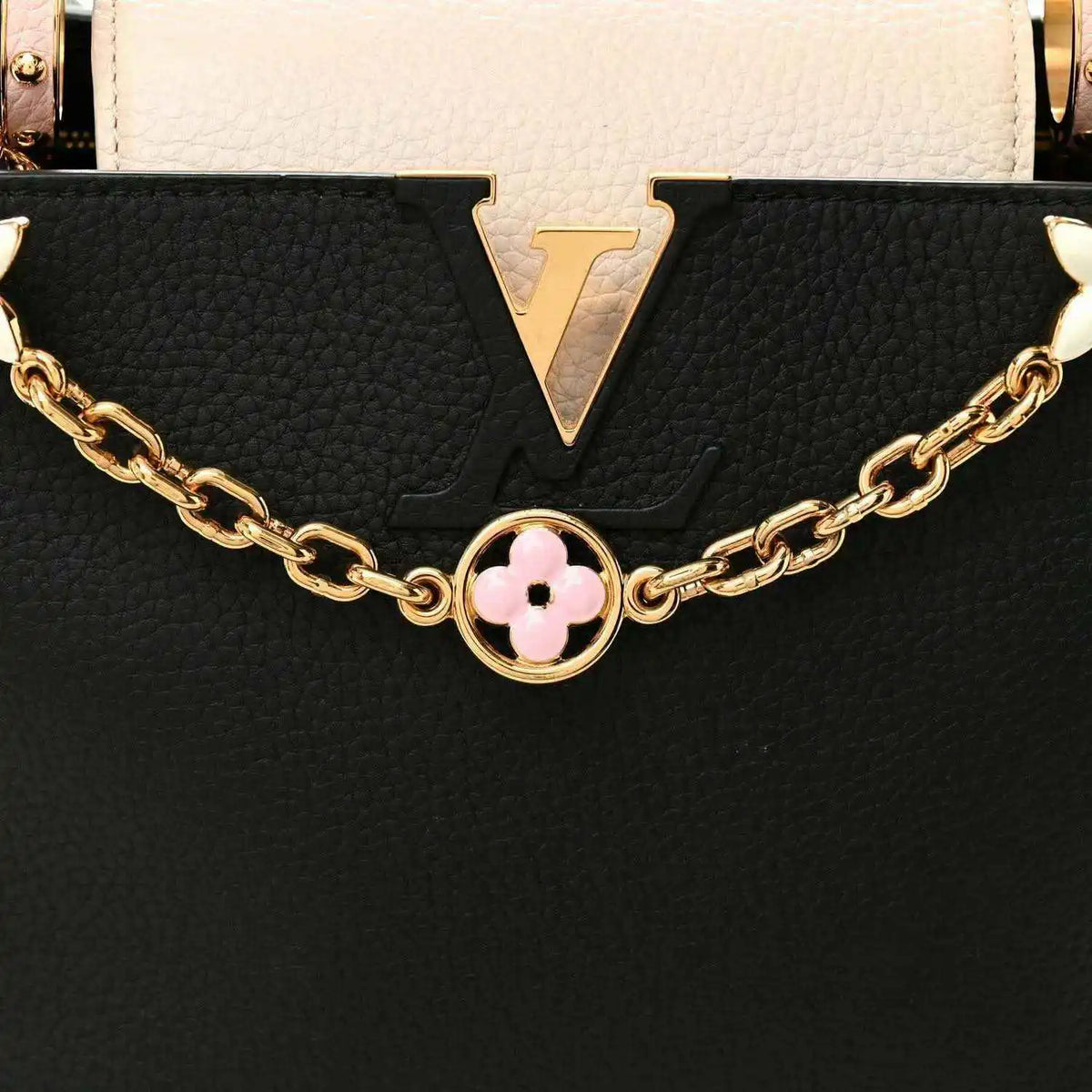 Black and cream leather handbag with gold chain and pink flower logo charm