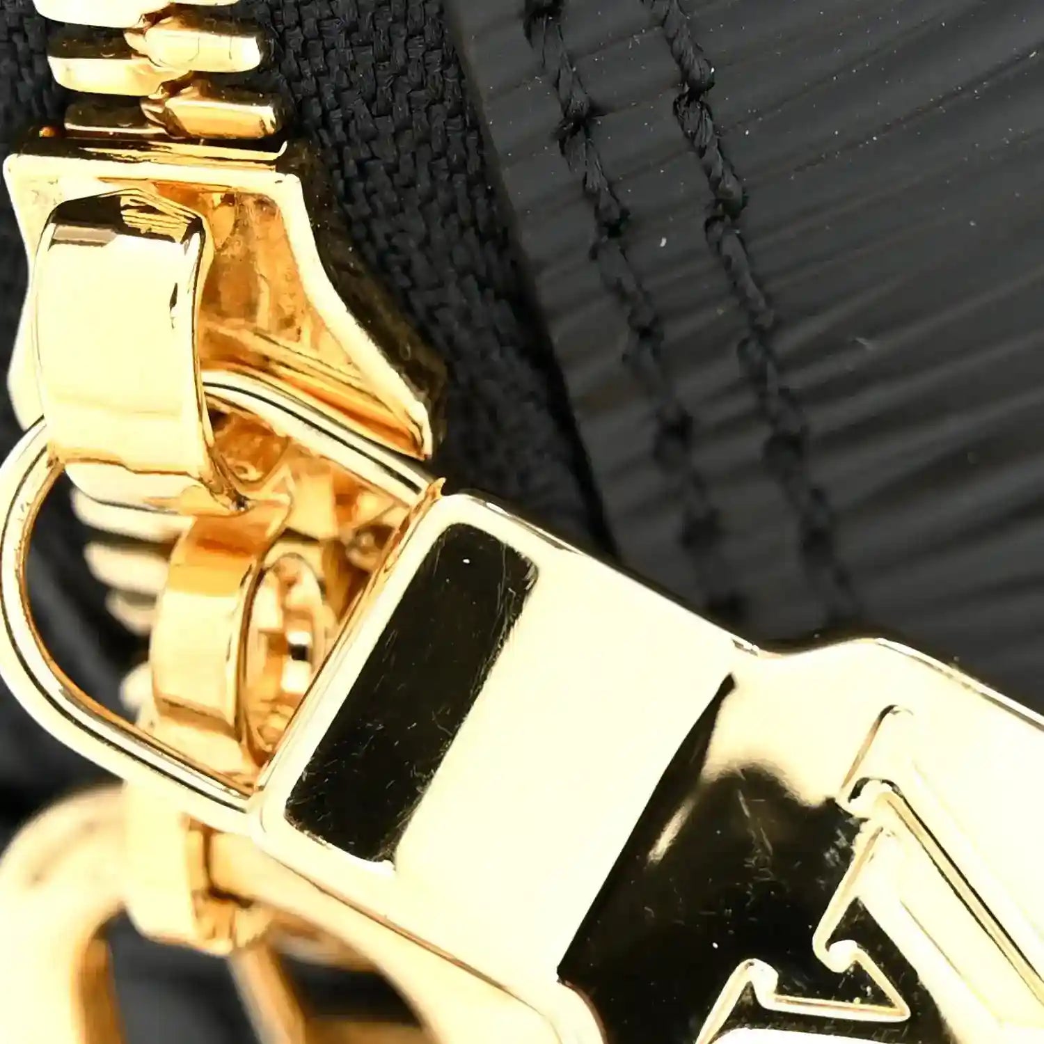 Gold-tone clasp hardware on a black handbag with decorative edge stitching