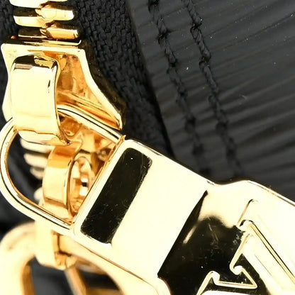 Gold-tone clasp hardware on a black handbag with decorative edge stitching