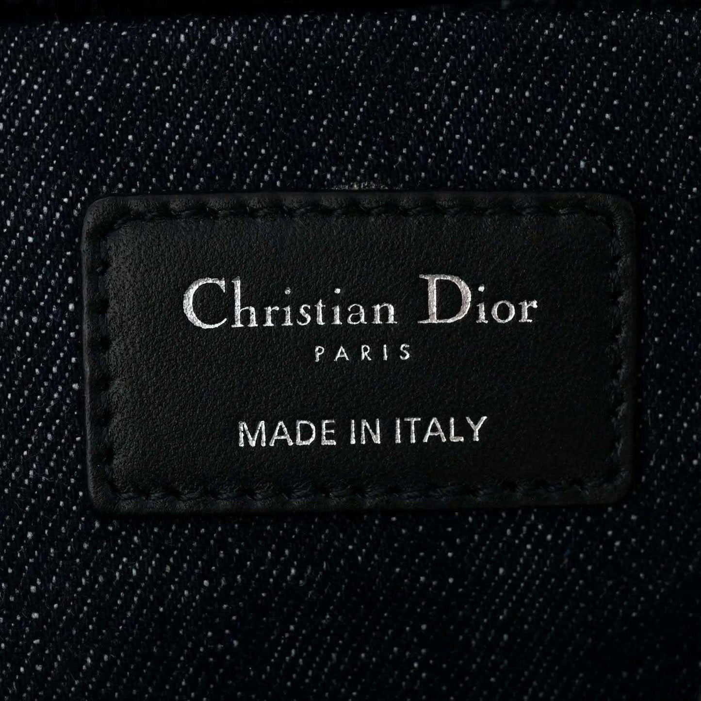 Christian Dior Paris label on dark blue denim handbag interior reading Made in Italy