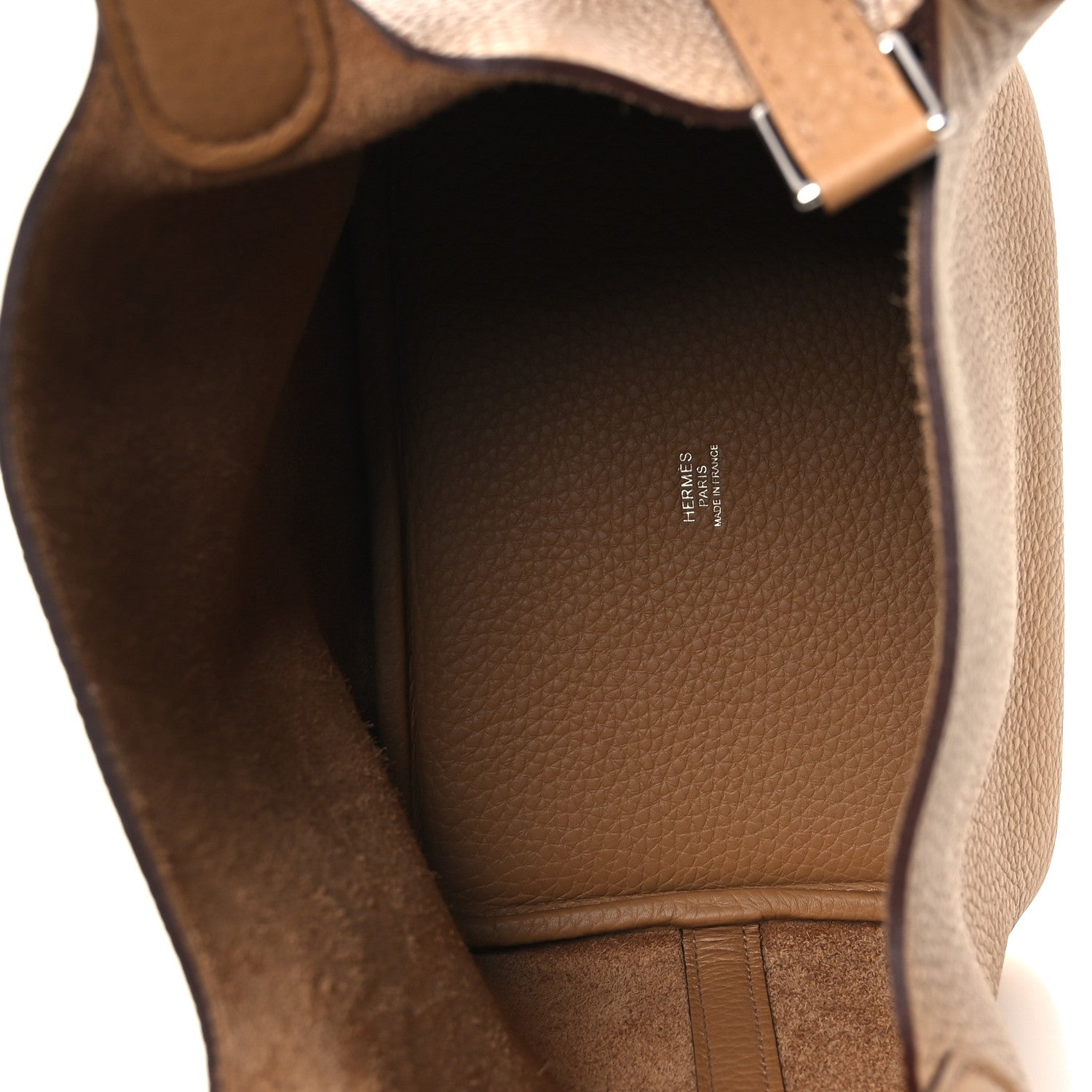 Tan leather interior of a bucket bag with brand stamp and open top lining.