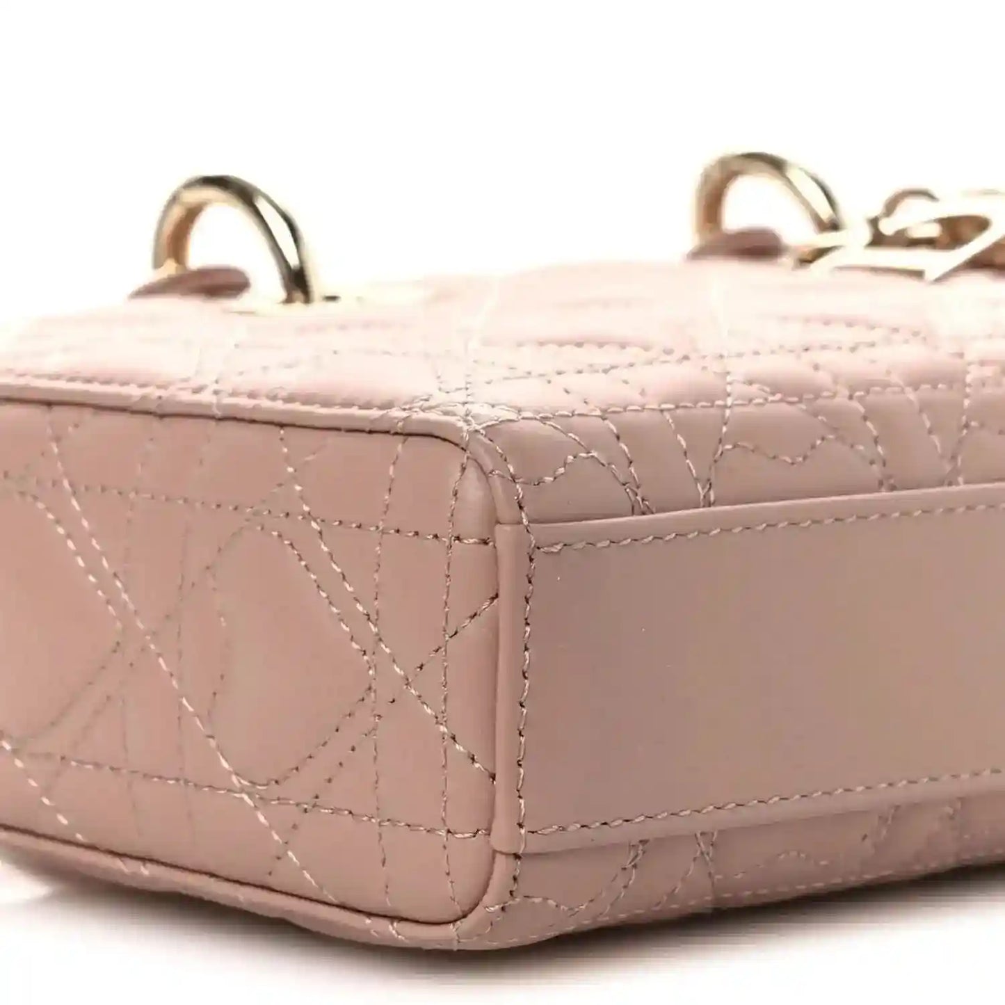 Pale pink quilted lambskin handbag side with structured shape and handle loops