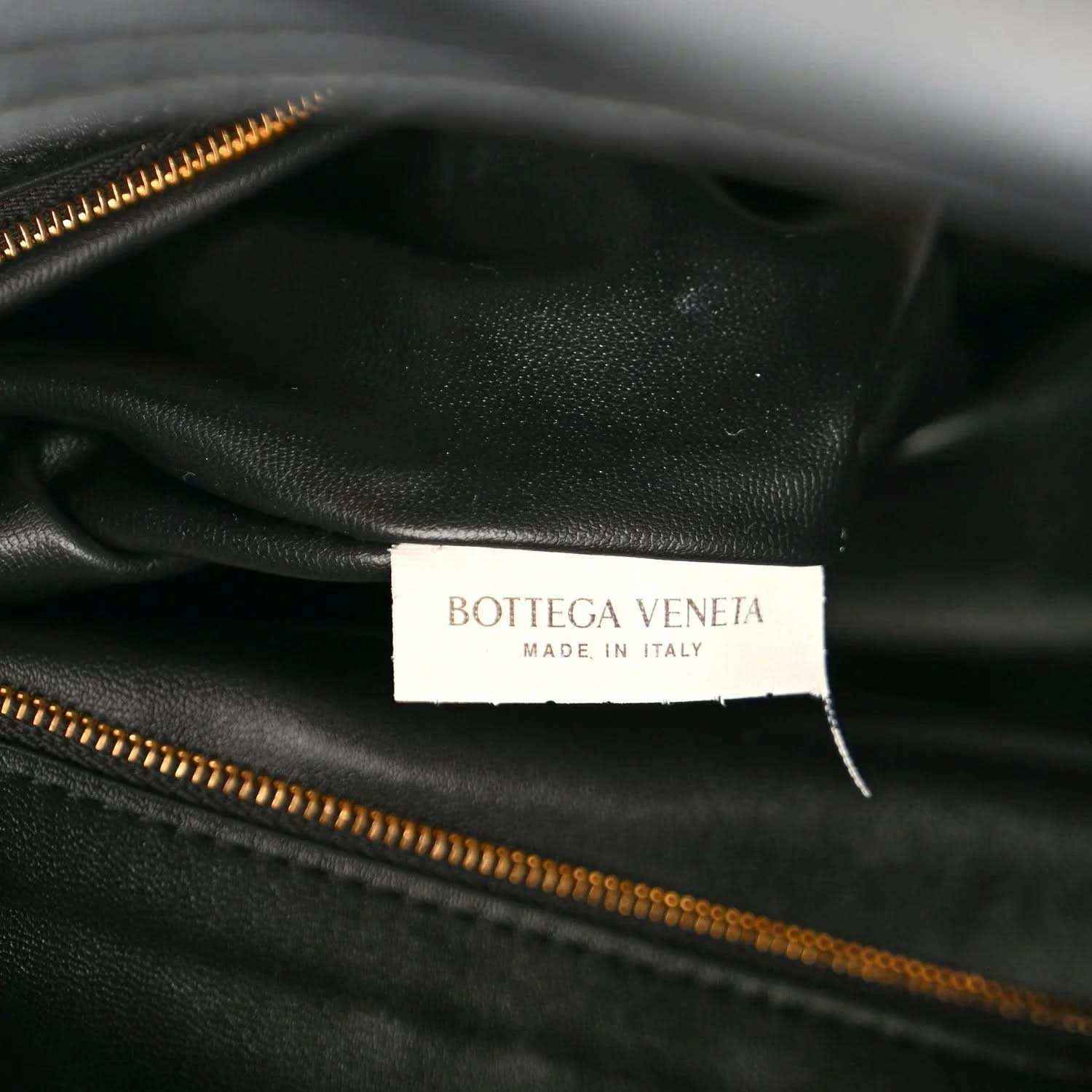 Black calfskin bag interior label with Bottega Veneta branding and gold zipper