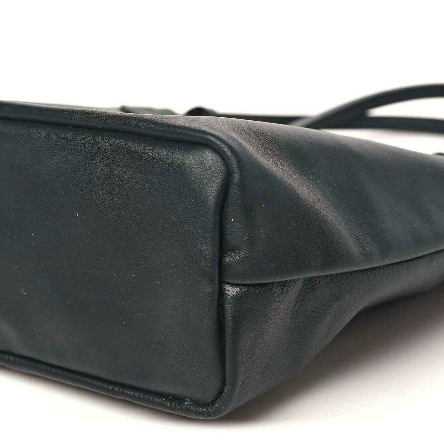 Black reversible mini tote bag side panel with rounded seam and stitched border.