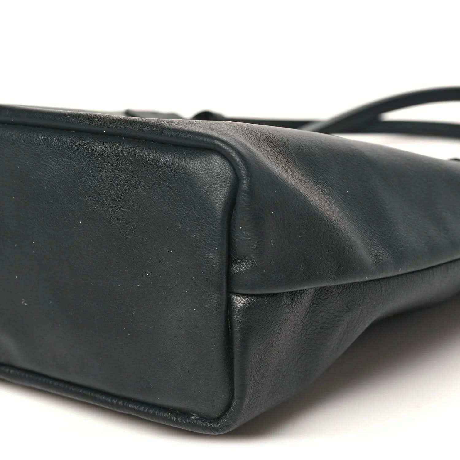 Black reversible mini tote bag side panel with rounded seam and stitched border.
