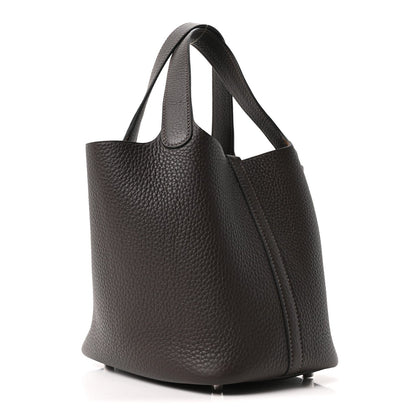 Dark brown leather tote bag with textured grain, side profile and slim front panel