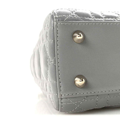 Grey quilted Lady Dior handbag corner with gold snap buttons and stitched trim