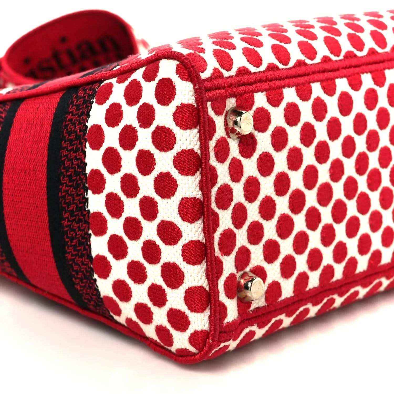 Red and white polka dot canvas bag with red trim, metal studs, and heart charm