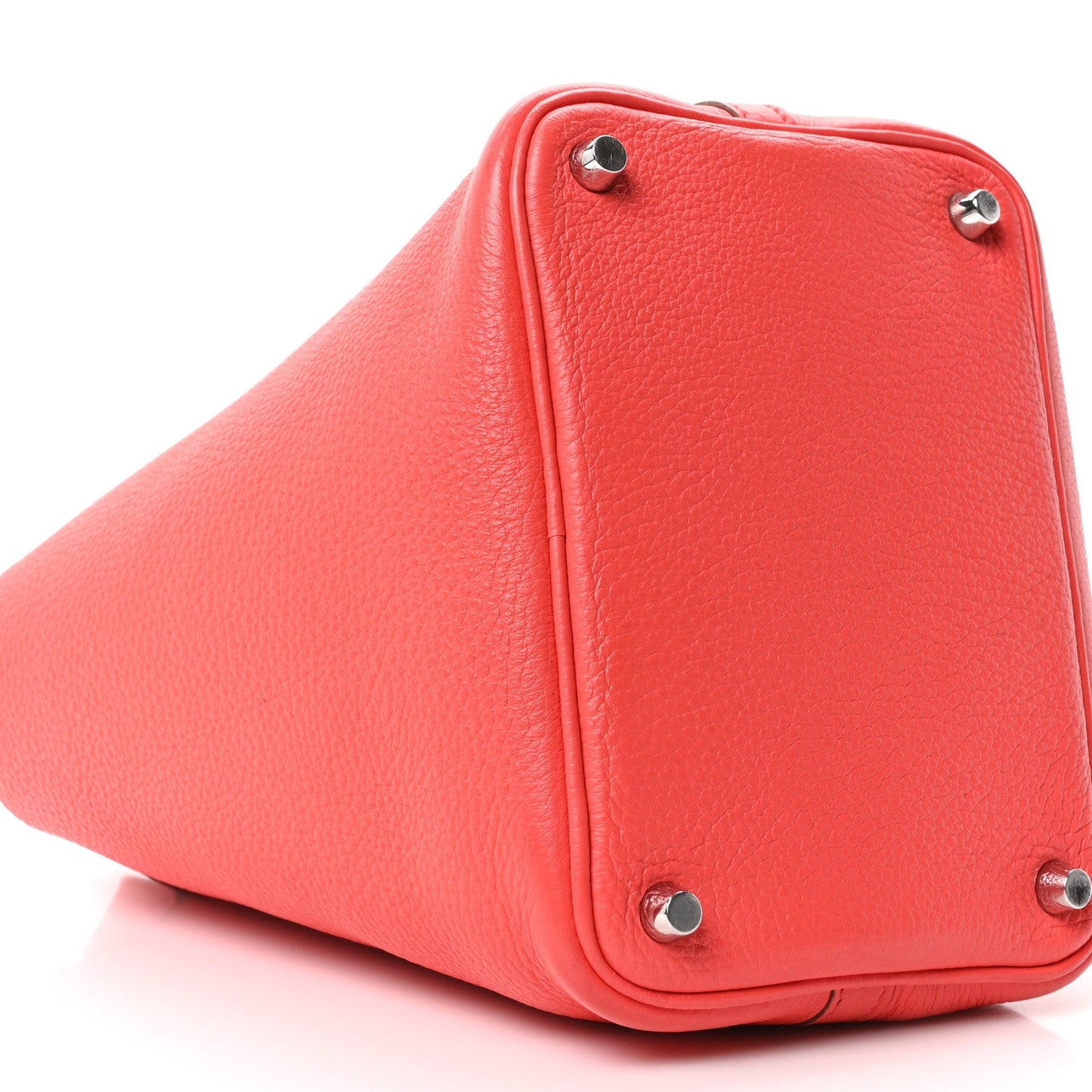 Red leather tote bag base corner with metal feet and side seam detail