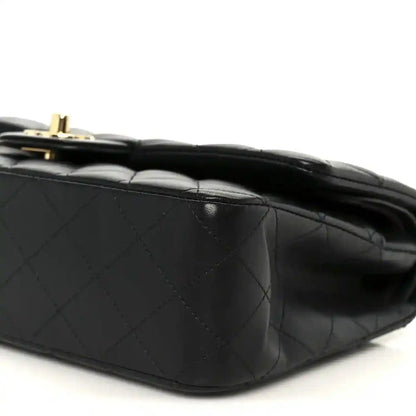 Black quilted lambskin shoulder bag, close-up of diamond stitching and flap edge