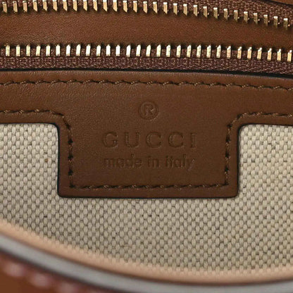 Gucci label reading “Made in Italy” on brown leather and beige canvas