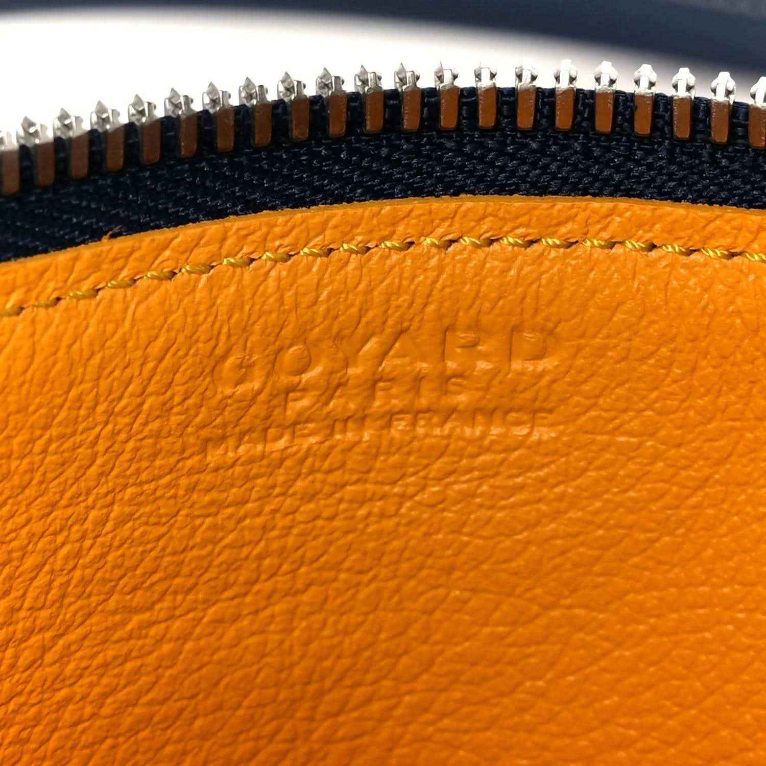 Close-up of Goyardine Bonbonniere bag zipper hardware and navy canvas edge