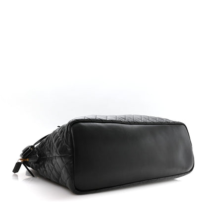 Black quilted leather travel bag with top zip and smooth end panel
