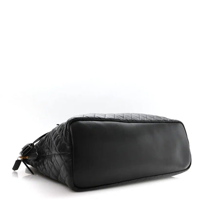 Black quilted leather travel bag with top zip and smooth end panel