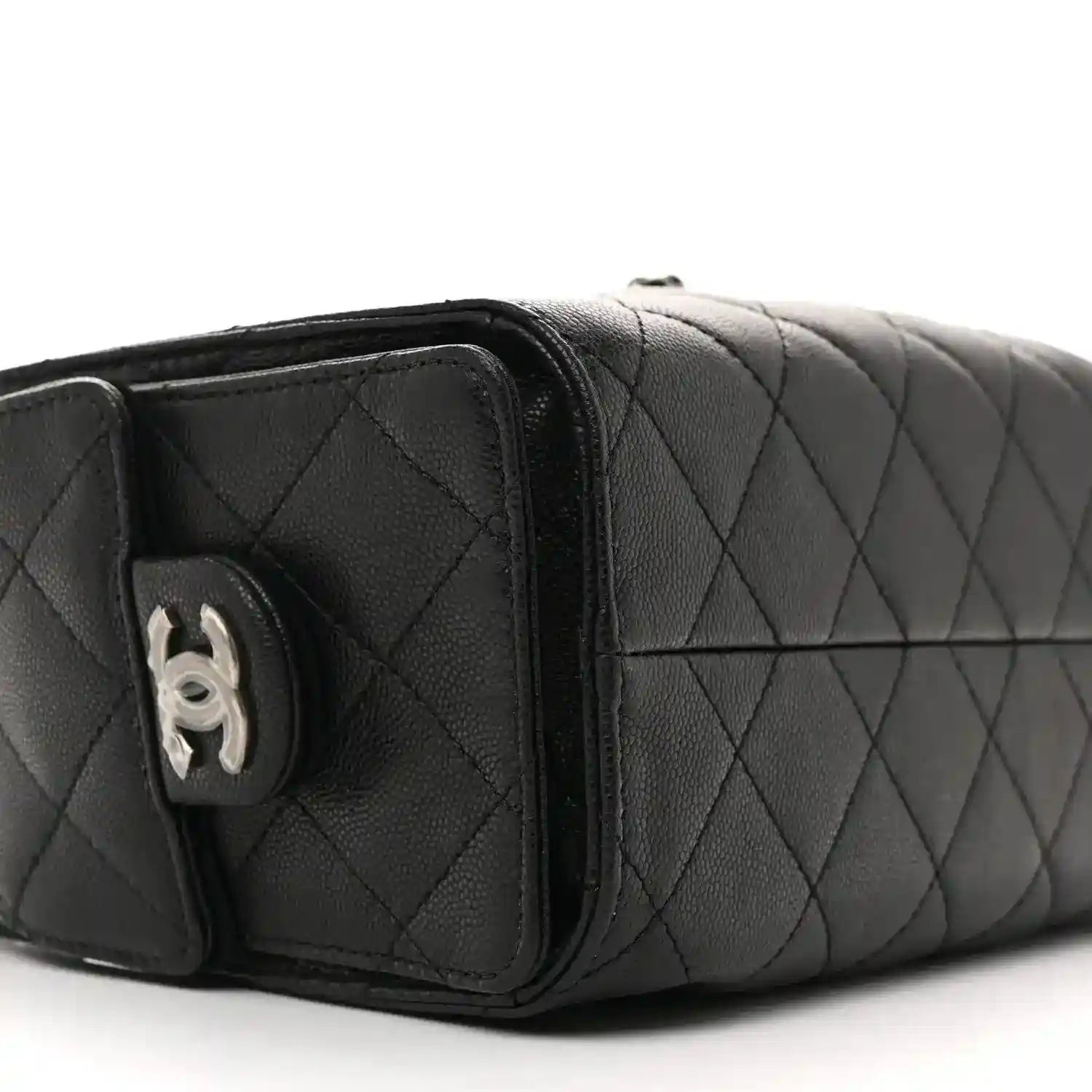 Black quilted mini shoulder bag side panel with CC logo medallion and strap loop.