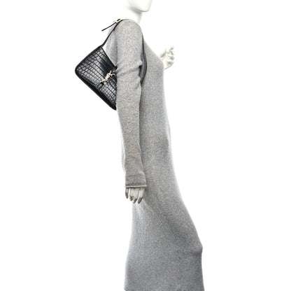 Black crocodile-embossed hobo shoulder bag worn on shoulder