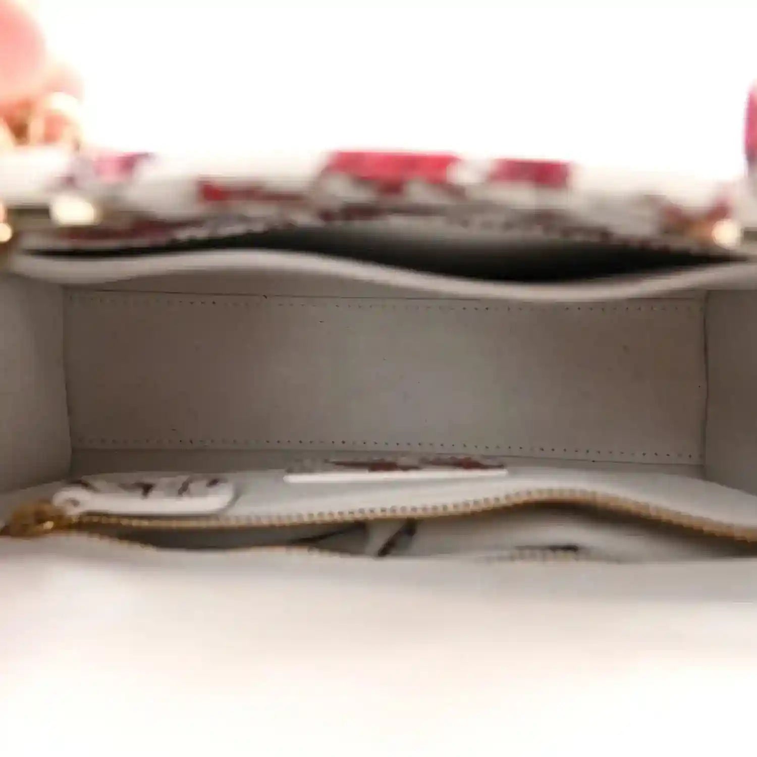 Handbag interior with light lining and zipper track, showing an inner zip pocket
