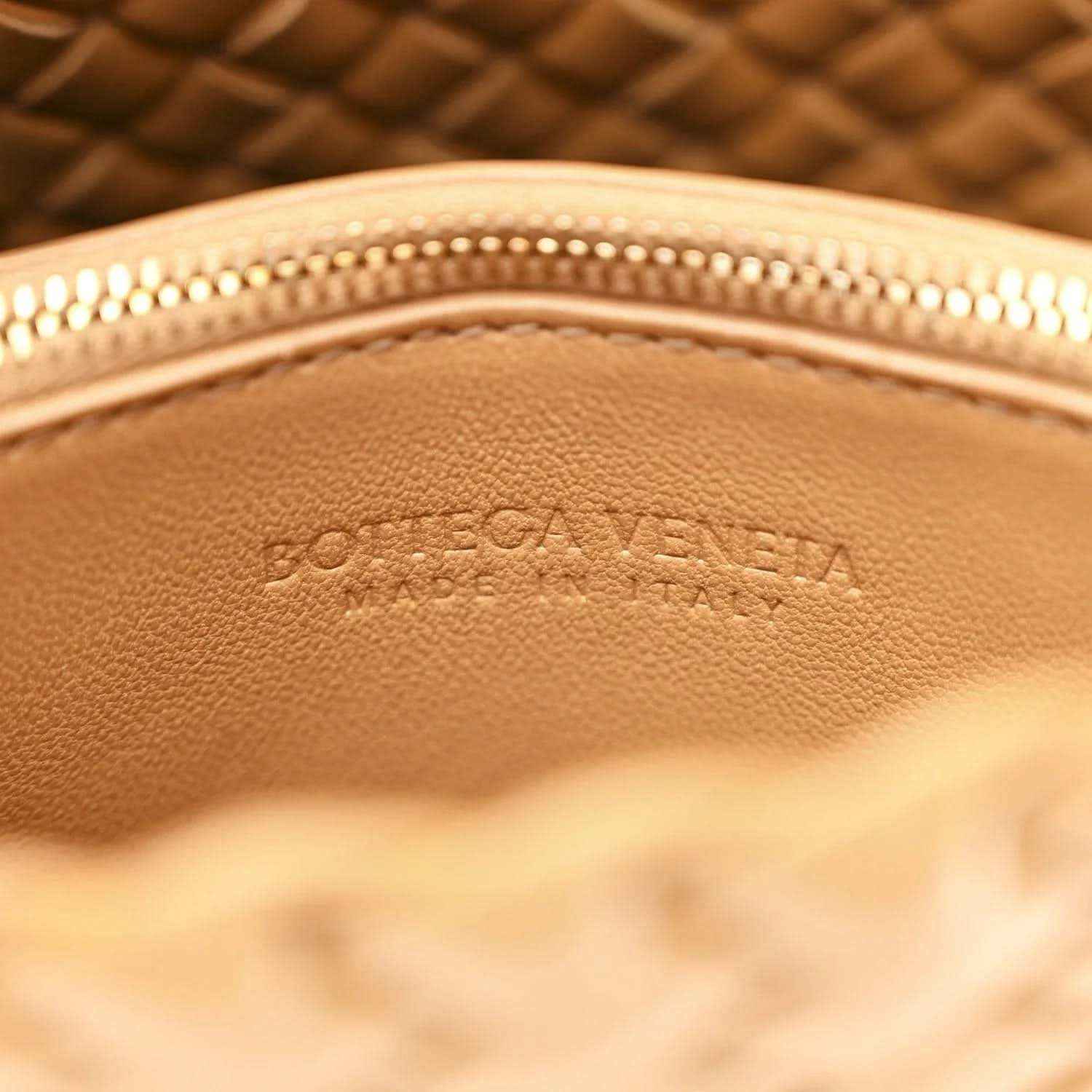 Caramel leather bag interior with stamped logo and gold-tone zipper edge