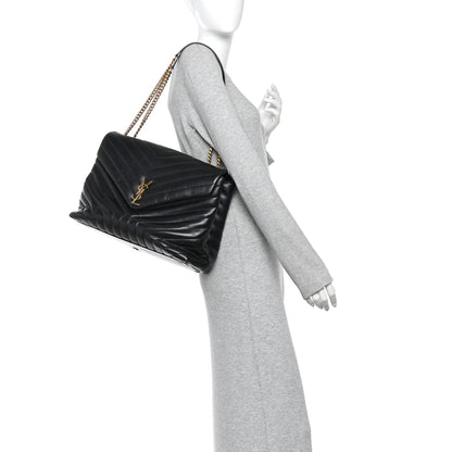 Black quilted calfskin satchel with gold chain strap, worn crossbody