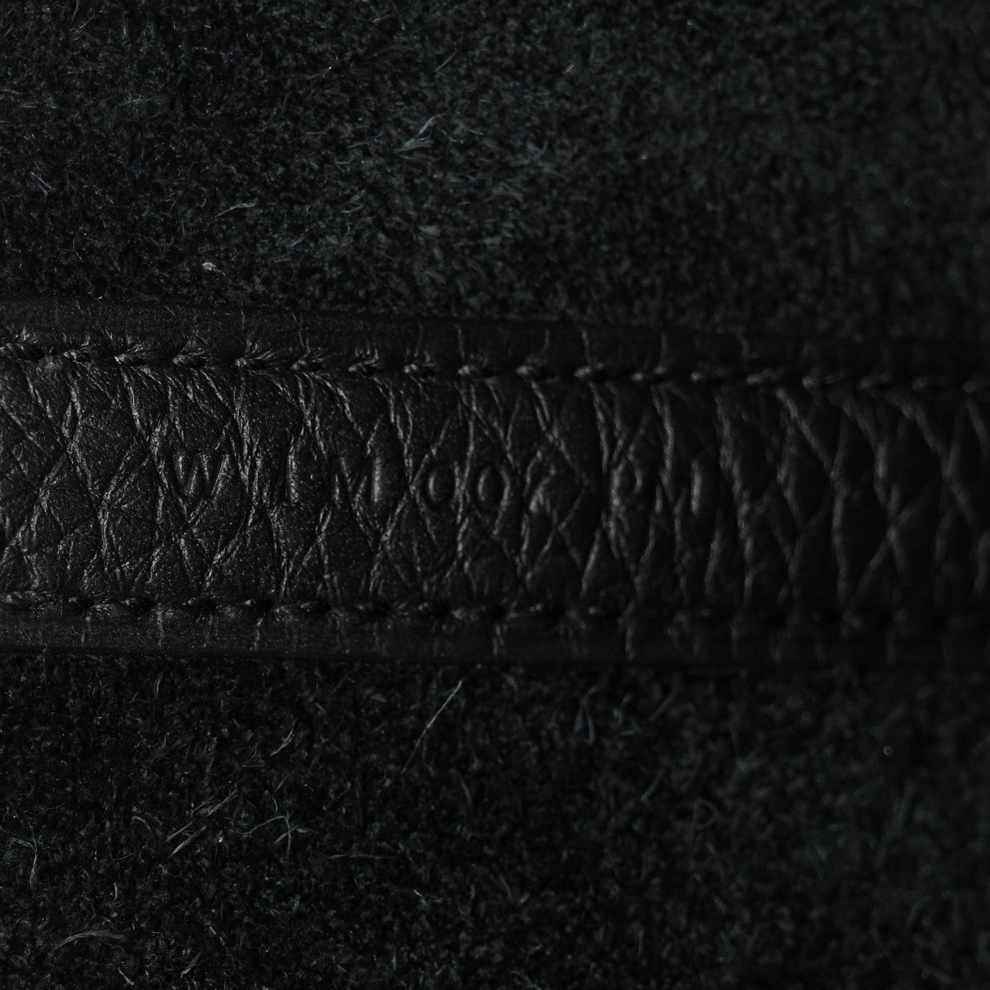 Black pebbled leather close-up of stitched edge
