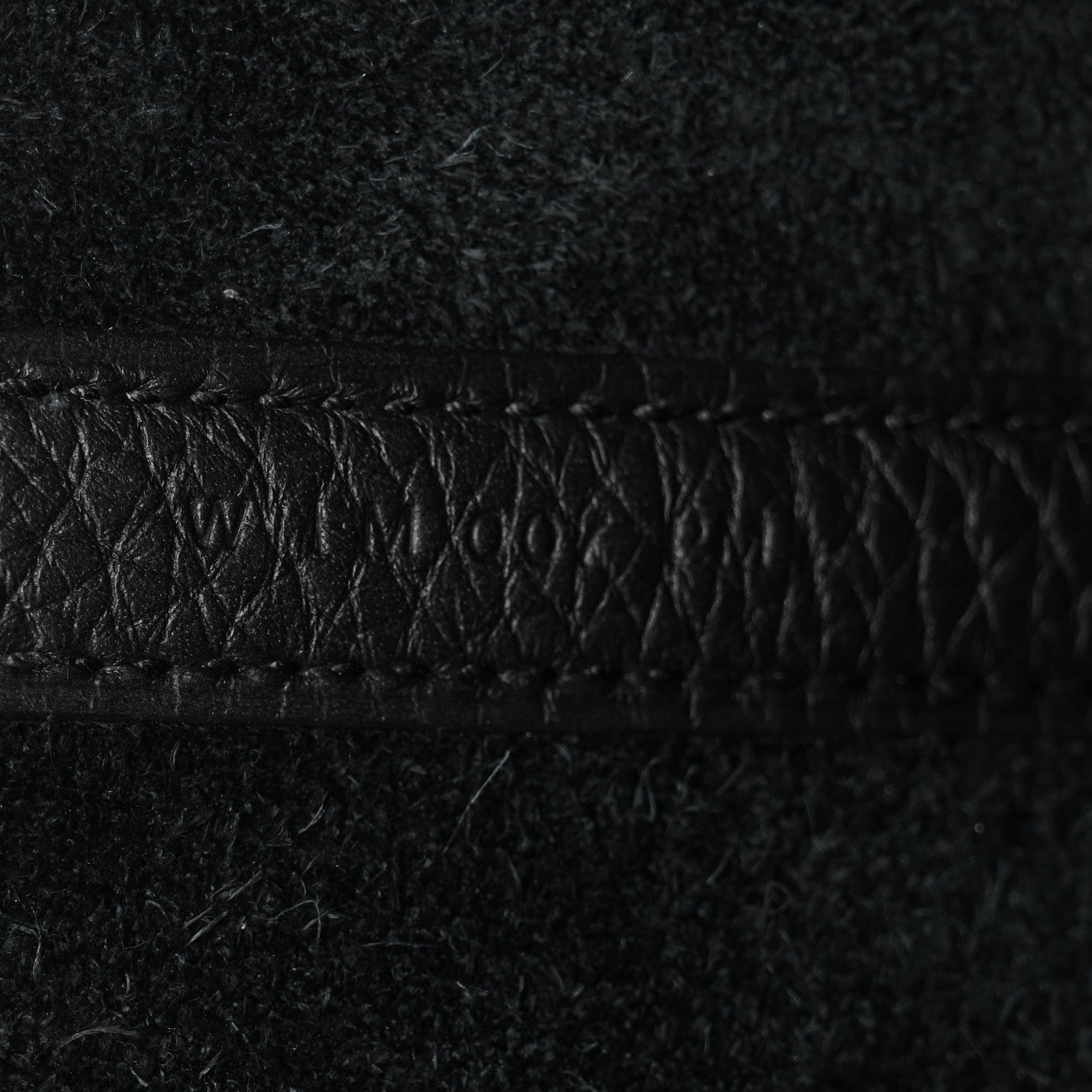 Black pebbled leather close-up of stitched edge