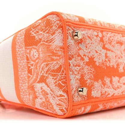 Orange toile de Jouy embroidered bag end with zip pull and side stripe panel.