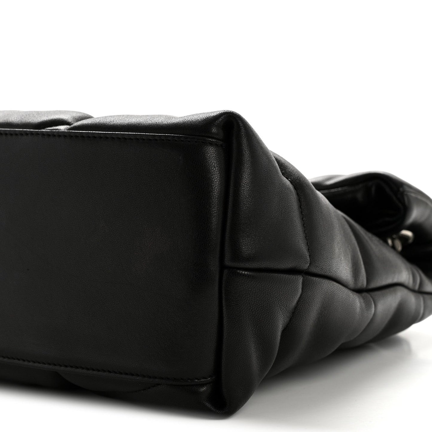 Black quilted puffer satchel end panel with stitched edge and curved side profile