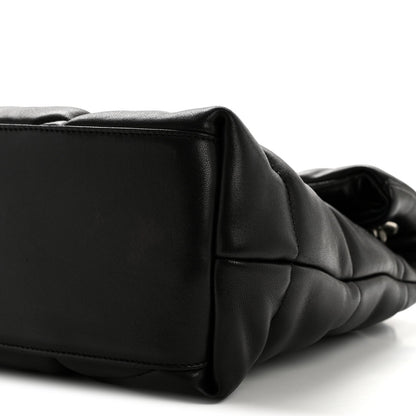 Black quilted puffer satchel end panel with stitched edge and curved side profile