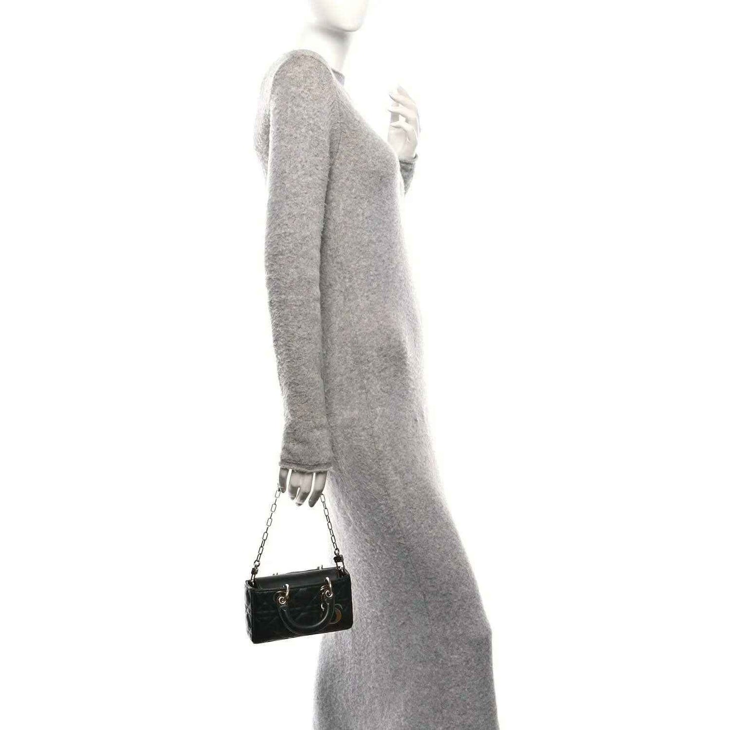 Black quilted mini handbag on shoulder with chain strap and small gold-tone clasp