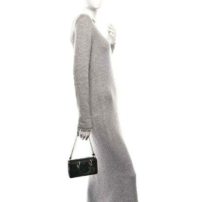 Black quilted mini handbag on shoulder with chain strap and small gold-tone clasp