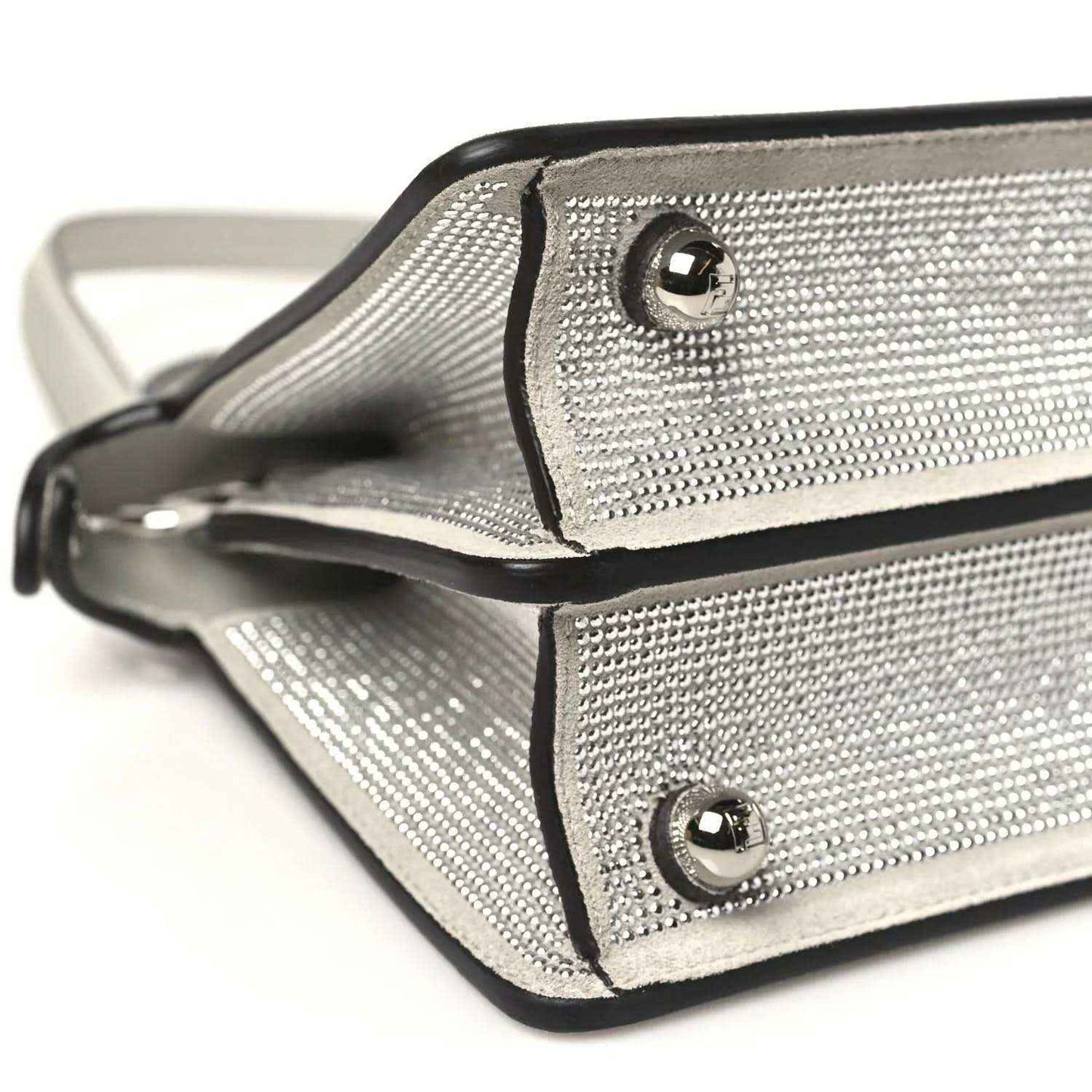 Small satchel front corner close-up with flap strap and round metal snap buttons