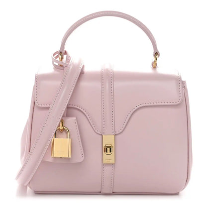 Pastel pink mini top-handle bag with flap front, gold lock detail, and shoulder strap