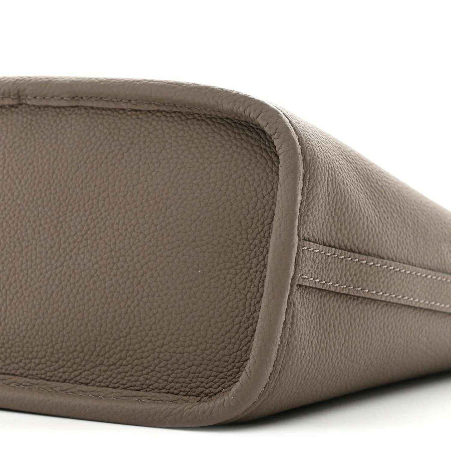 Gray pebbled leather end panel with curved seam and stitched pocket-like shape