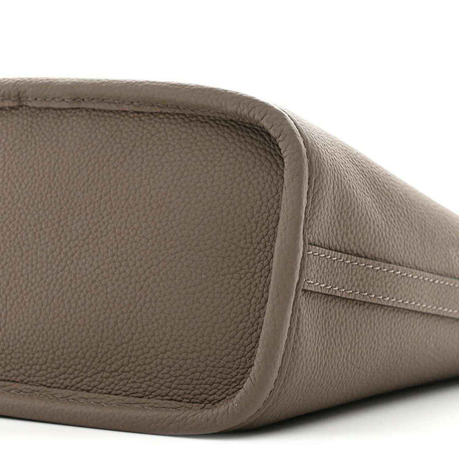 Gray pebbled leather end panel with curved seam and stitched pocket-like shape