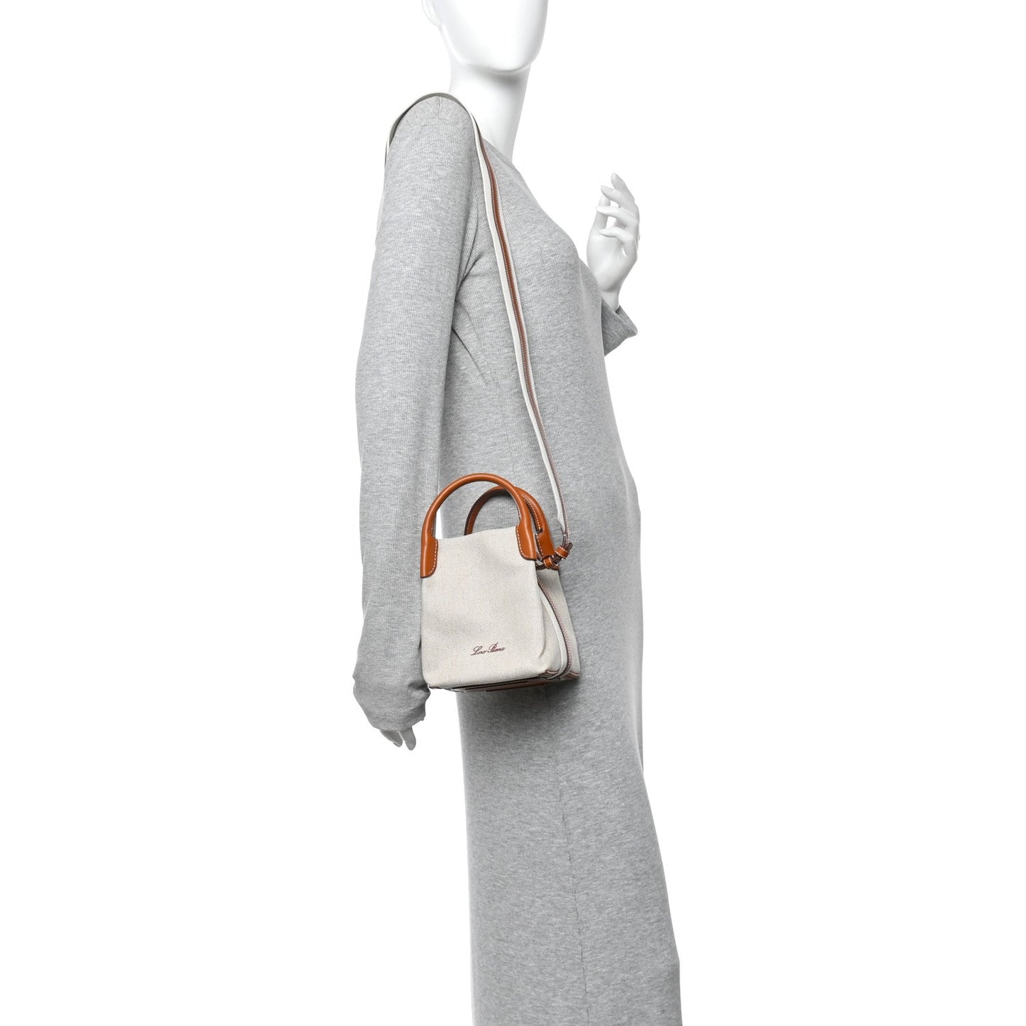 Loro Piana micro bale bag on model, natural canvas with tan leather strap and handles.