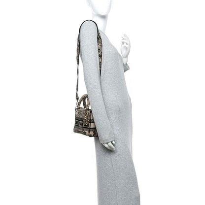 Mini embroidered handbag worn on shoulder; black-and-cream fabric with gold hardware