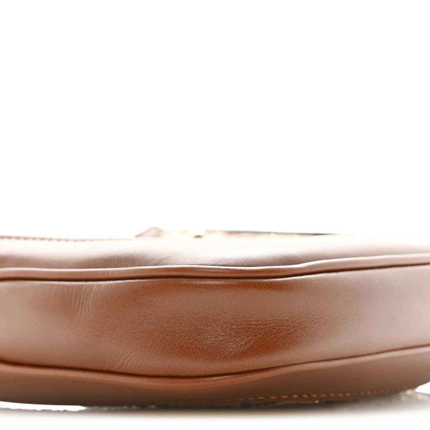 Mini hobo bag side panel close-up in tan leather with subtle creasing and stitched edge