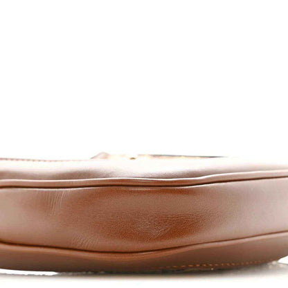 Mini hobo bag side panel close-up in tan leather with subtle creasing and stitched edge